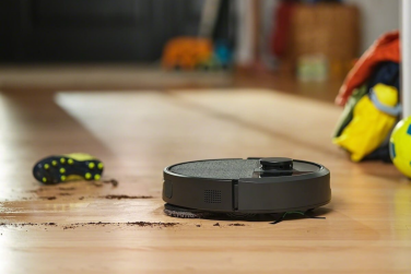 Roomba Plus 405 Combo mopping dirt on floor with soccer equipment in background