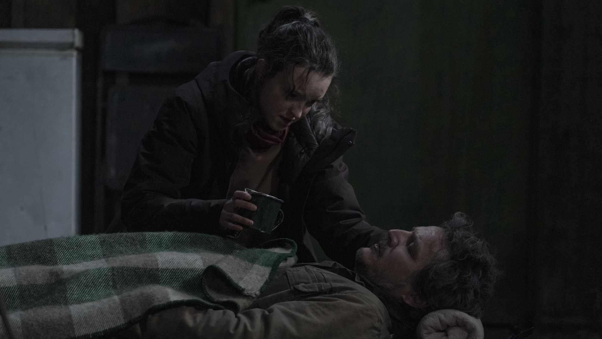 A teen girl tends a wounded man in an abandoned house.