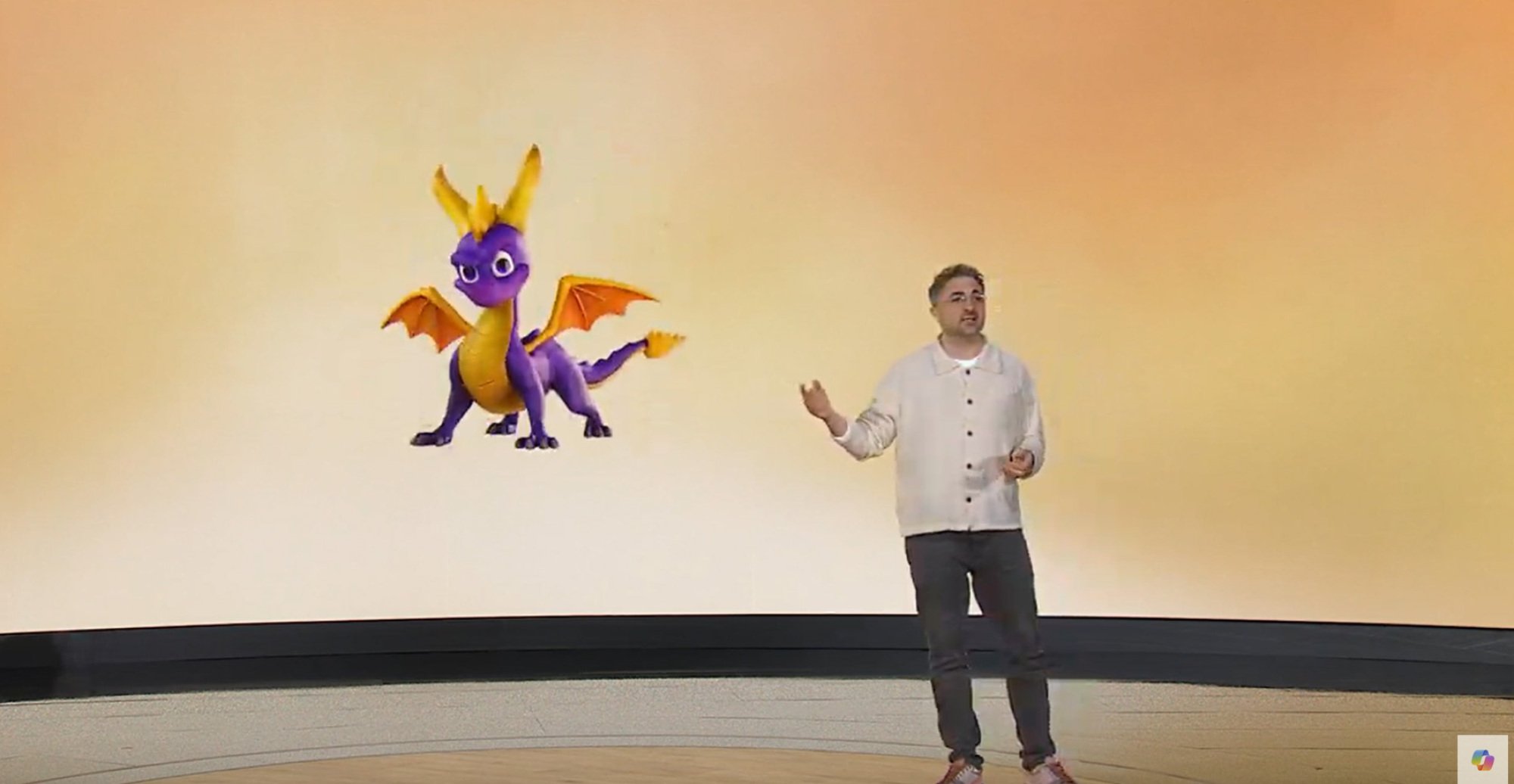 A man standing in front of a screen with Spyro the Dragon on it.