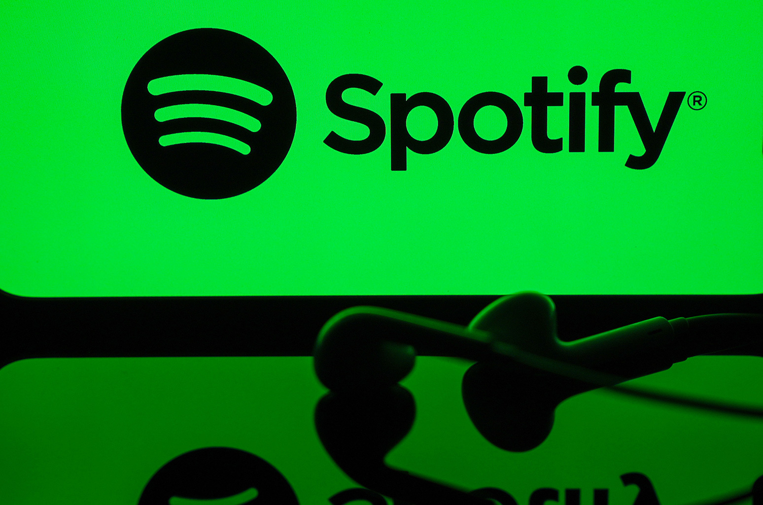 In this photo illustration a mobile phone screen displaying Spotify logo with a headset in front of it, in Ankara, Turkiye on May 01, 2024.