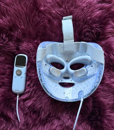 Shark CryoGlow face mask laying on fur rug