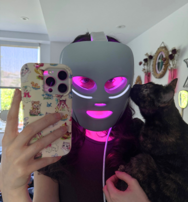 Woman wearing Shark CryoGlow face mask and holding cat