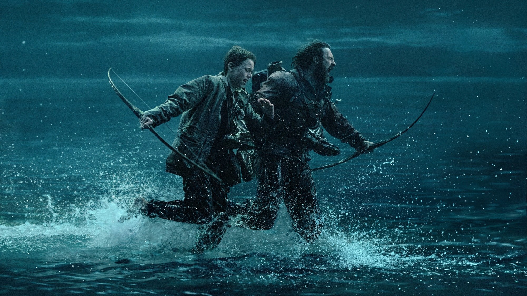 Aaron Taylor-Johnson and Alfie Williams run across water in "28 Years Later."