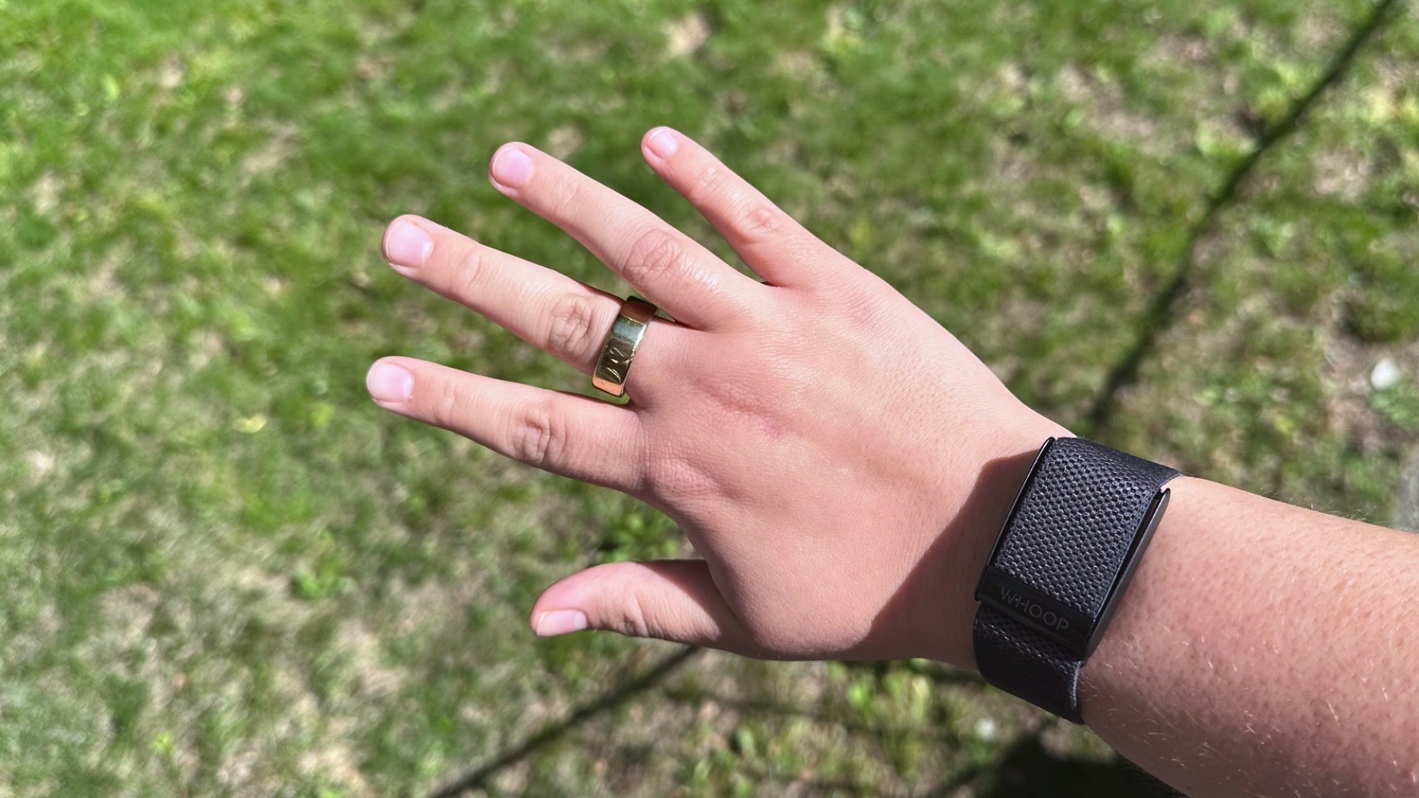 the oura ring 4 and whoop fitness tracker on a woman's hand