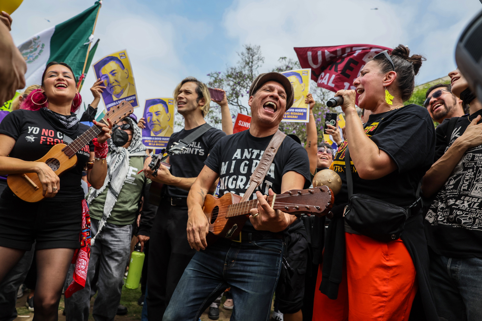 Members of Las Cafeteras lead supporters in song at a rally in support of union leader David Huerta at Grand Park, Los Angeles.