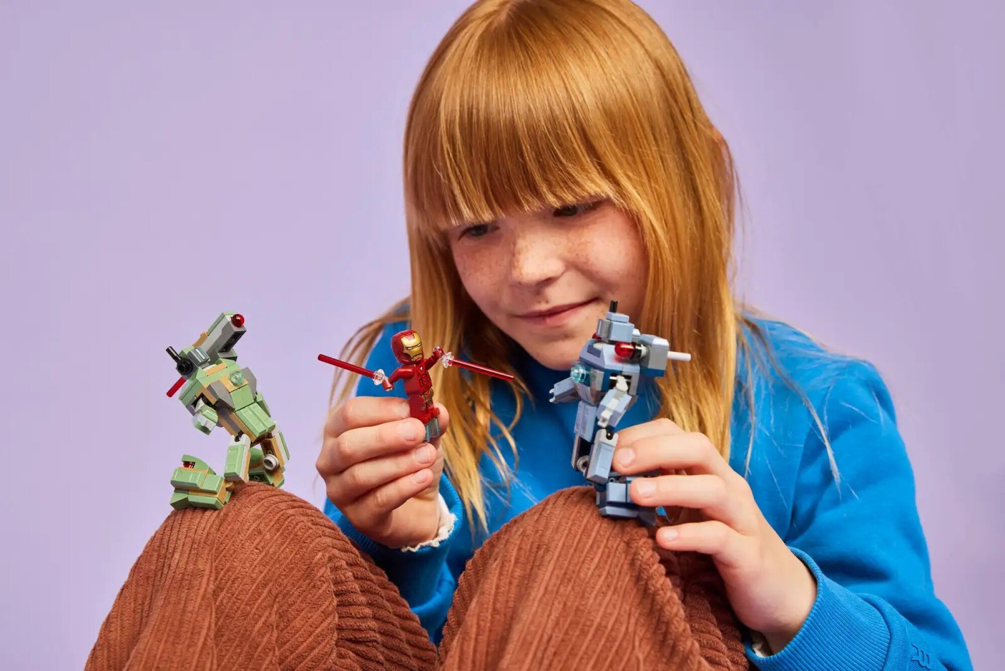 child playing with the iron man and war machine vs. hammer drones lego set