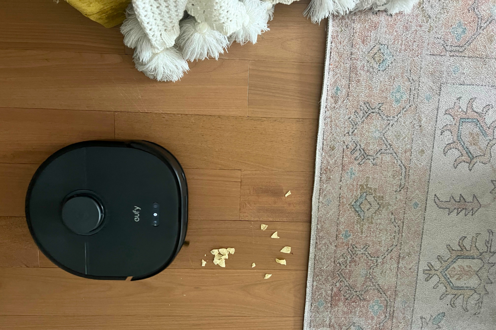 Eufy X10 Pro Omni robot vacuum cleaning chip crumbs on hardwood floor
