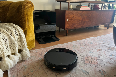 Roborock Saros 10R robot vacuum cleaning rug in front of self-empty dock