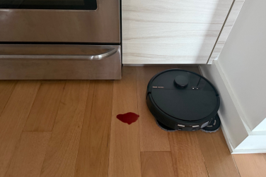 Roomba Plus 505 Combo robot vacuum mopping hardwood floor in kitchen near wine spill