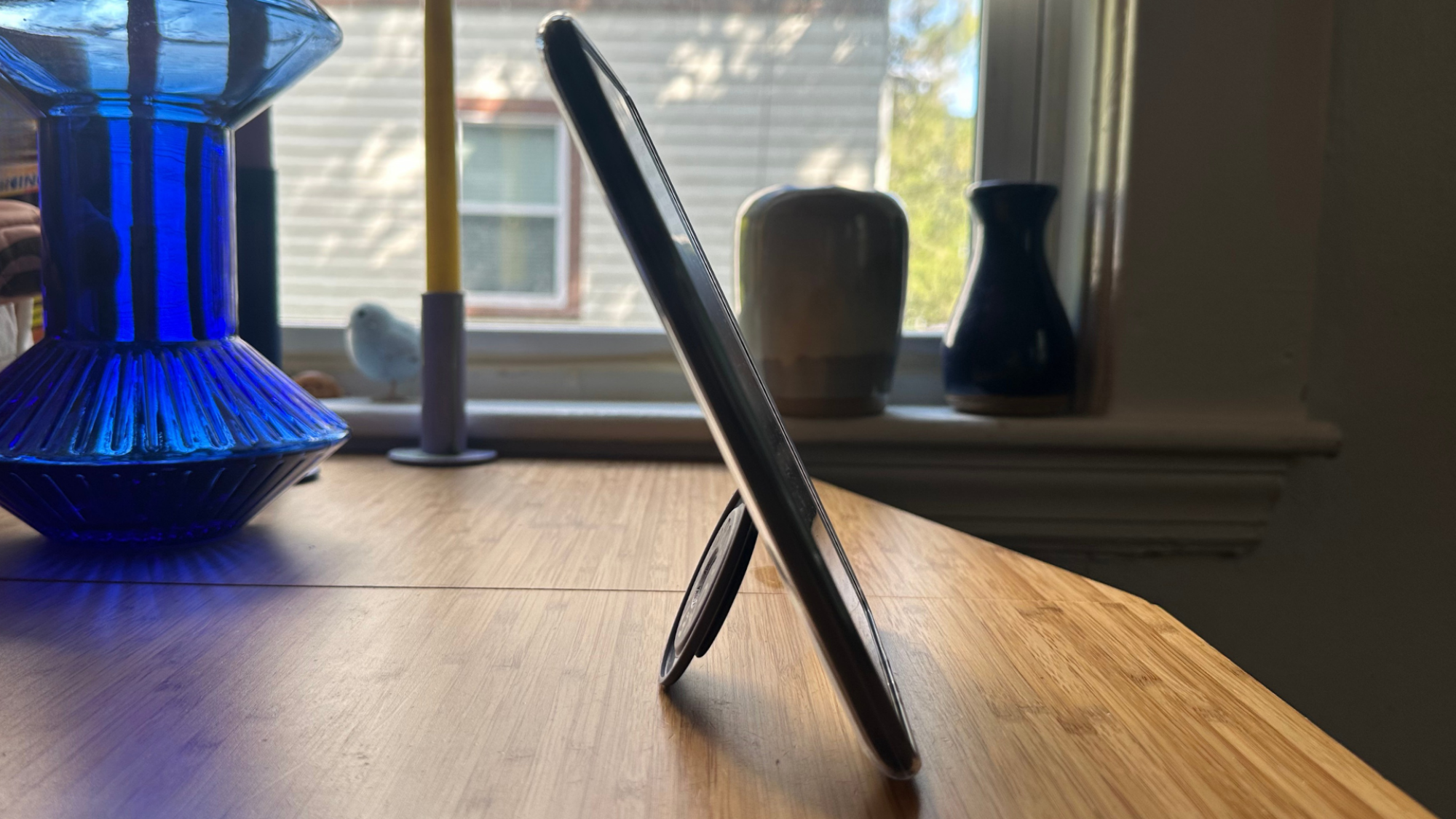 A Kindle propped up by a PopSockets Kick-Out stand.