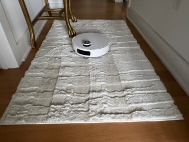 Dreame Aqua10 Ultra Roller robot vacuum cleaning white rug